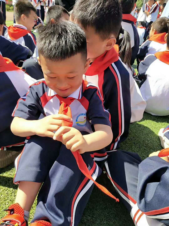 汶上县第三实验小学新入队小男孩姬文哲手抚红领巾