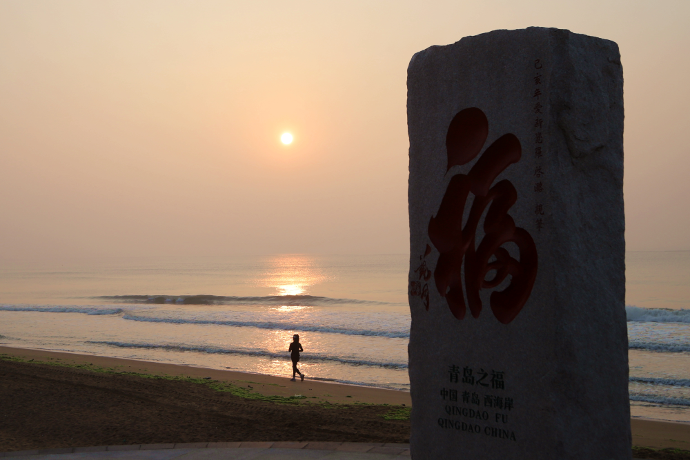 6月19日清晨,在青岛西海岸新区灵山湾海水浴场,一名市民沿着海边跑步.