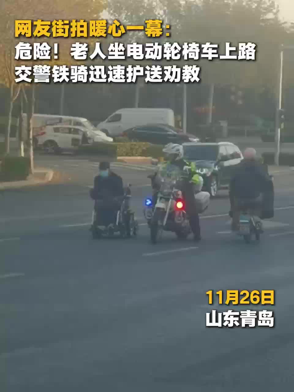 青岛:老人坐电动轮椅车上路 铁骑队员温情守护