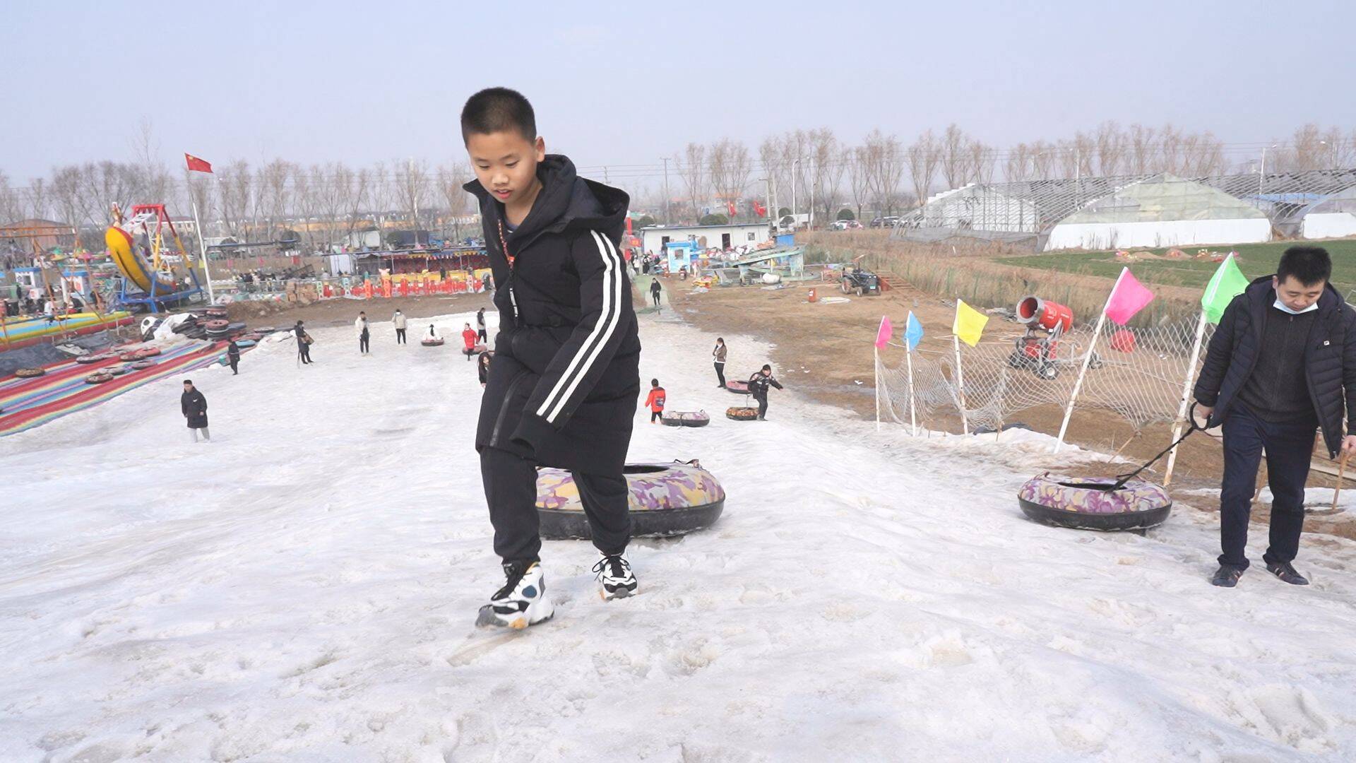 春节期间,在单县浮岗镇滑雪场,整个雪场宛若一片冰雪世界,银装素裹.