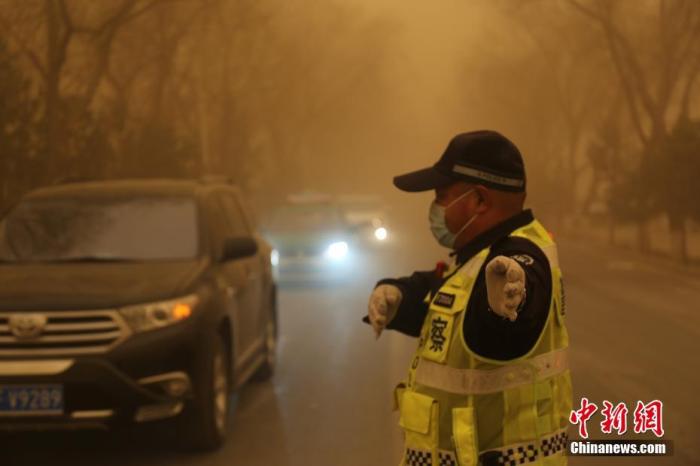 3月15日，甘肅多地遭遇沙塵天氣，一名交警戴口罩執(zhí)勤。 胡廣信 攝