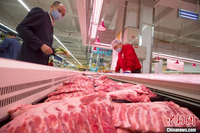 資料圖：消費(fèi)者正在選購(gòu)豬肉。<a target='_blank' >中新社</a>記者 張?jiān)?攝