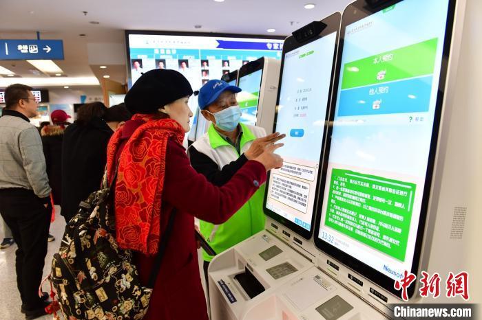  患者在指导下使用人脸识别系统预约专家号。 王广兆 摄