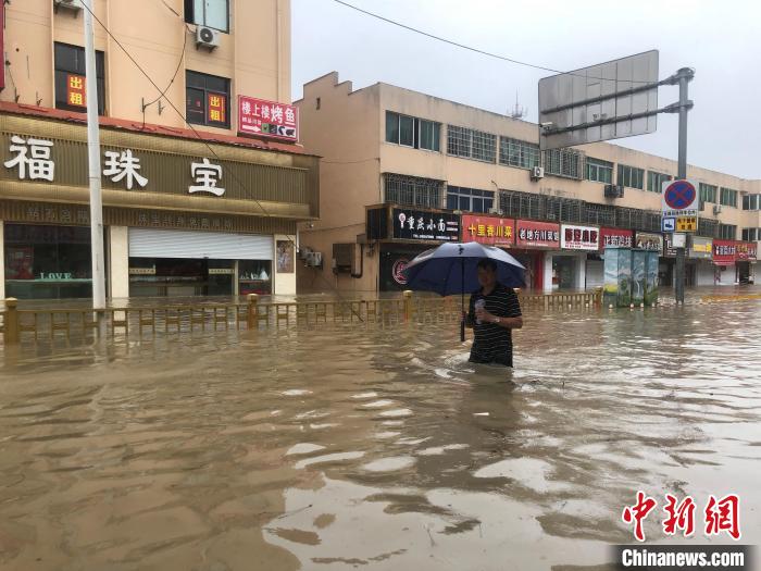 洞橋鎮(zhèn)居民行走在積水中。 林波 攝