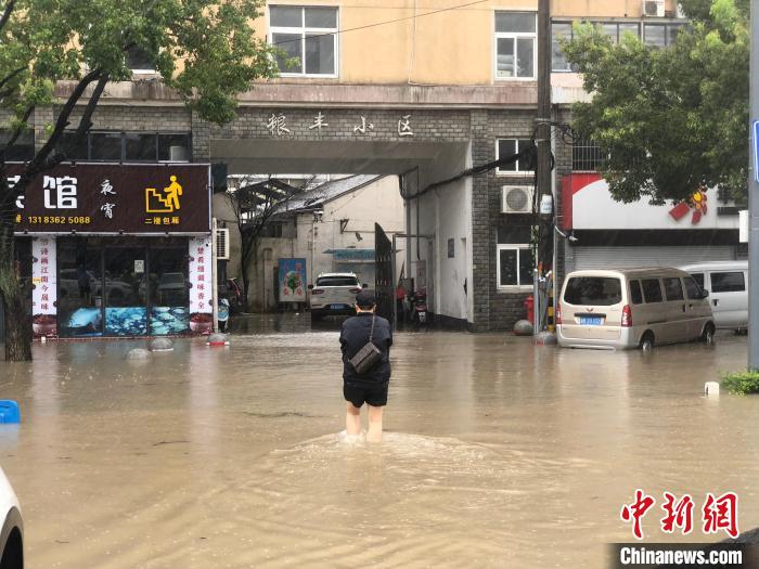 洞橋鎮(zhèn)居民行走在積水中。 林波 攝