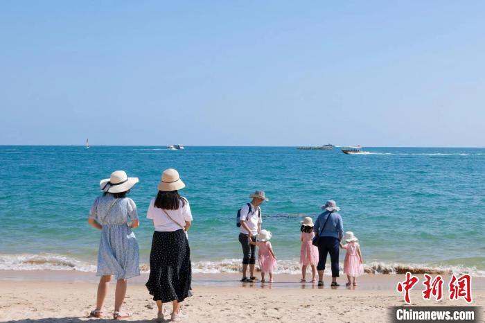 資料圖：家長(zhǎng)帶著孩子在海邊嬉浪。 游建行 攝