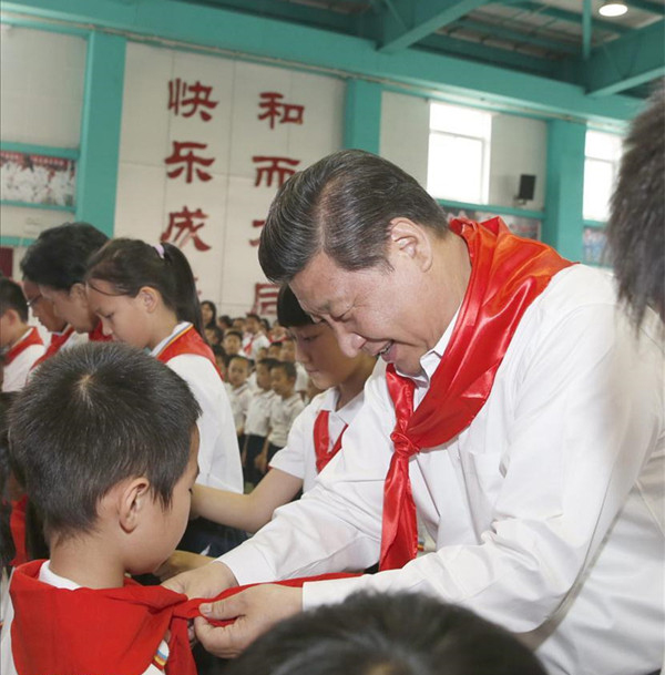 2014年5月30日，在北京市海淀區(qū)民族小學(xué)的少先隊(duì)入隊(duì)儀式上，習(xí)近平為新少先隊(duì)員系上紅領(lǐng)巾。