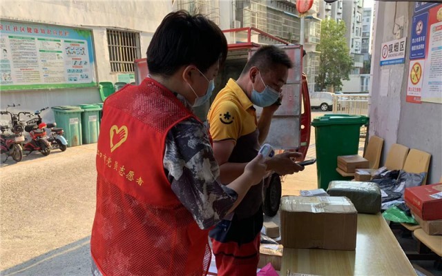 大学生志愿者正在对快递员进行体温检测。