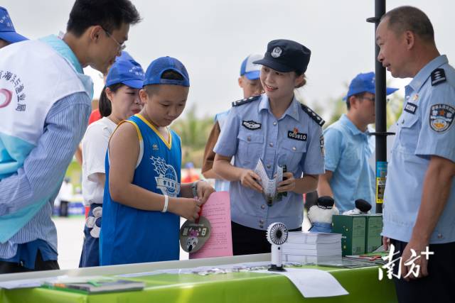 保護(hù)紅樹林生態(tài)系統(tǒng)國際日，民警們在湛江市區(qū)擺攤，科普紅樹林保護(hù)知識。