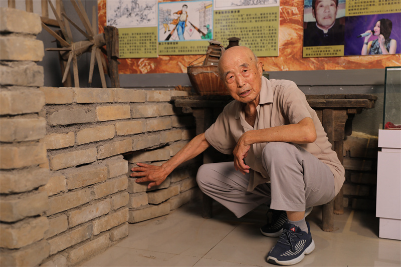 圖3：7月2日，李智凜在李家小院，演示土炕下的地道口模型。.jpg