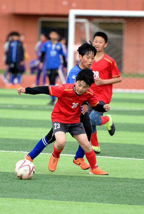 2021年4月13日,临沂市郯城县第一实验小学男子足球队队员李雨泽(前)在