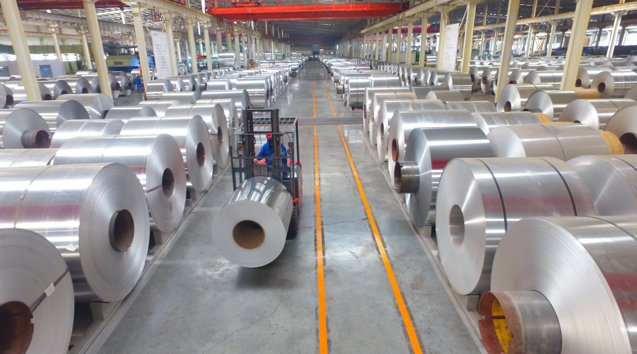 图/聊城市茌平区信通铝业有限公司车间内,工人正驾驶着叉车搬运铝卷