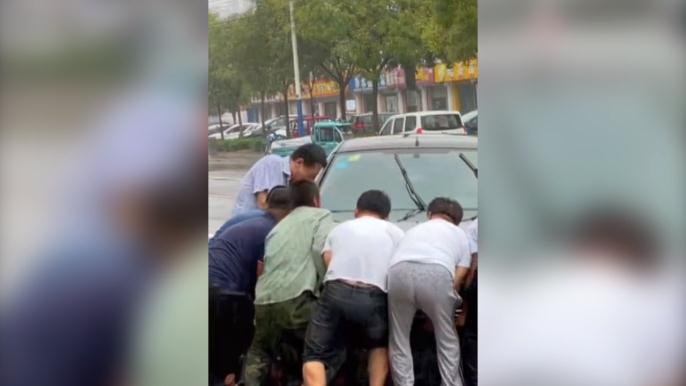 感人一幕！滨州一男子被卷入车底 路人冒雨抬车救人