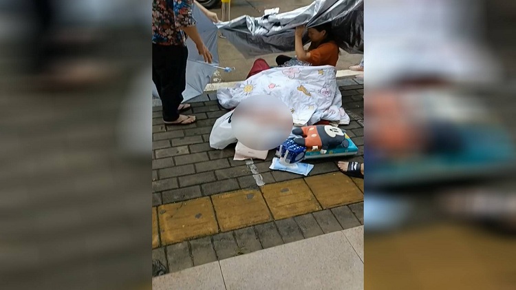 深圳一孕妇街头突感不适 行人拿来被子雨伞搭起“临时产房”
