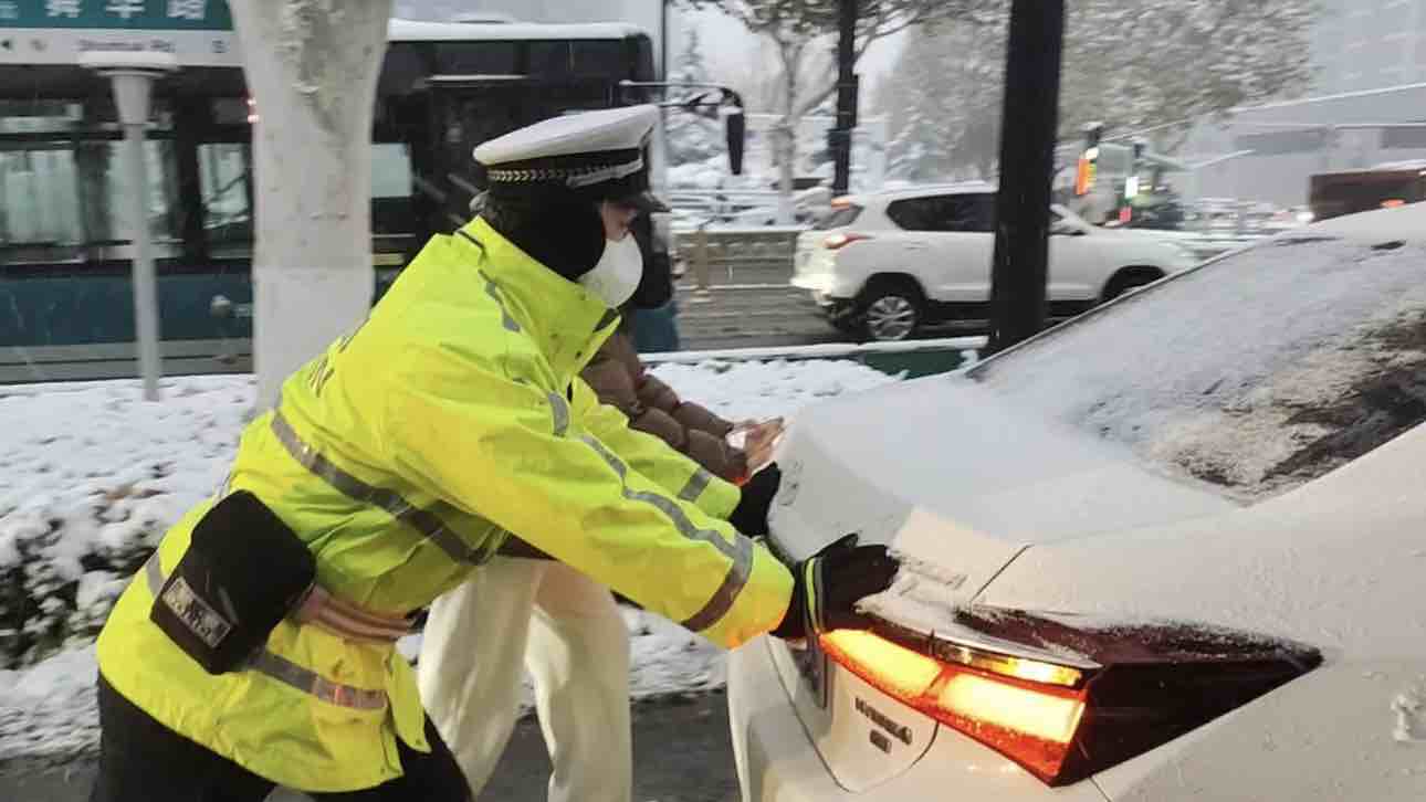 暖心！雨雪天气车辆打滑无法行驶 济南交警和市民合力推车帮司机解困