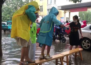 53秒｜雨中温情！校门口路面积水，老师用板凳为学生架起“小桥”
