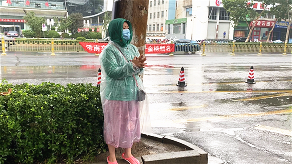 27秒丨济南一高考考点外，陪考的母亲在雨中伫立默默为孩子加油