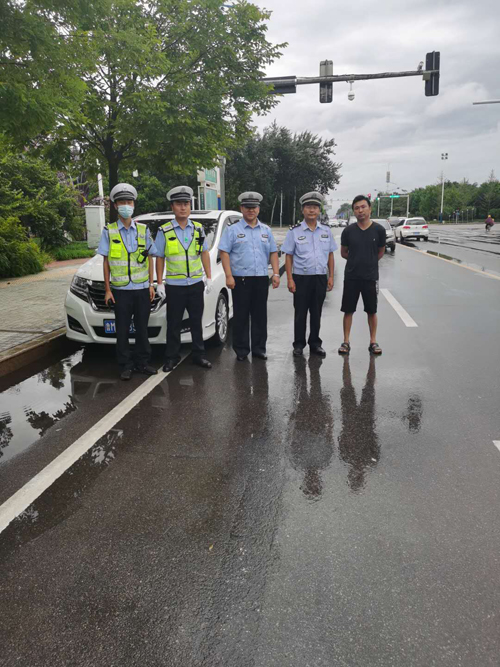 溫馨一幕！濱州一市民給雨中執勤交警送傘：這是我們應該做的