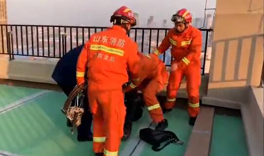 40秒丨惊险！济南一女子因债务纠纷欲轻生跳楼 被消防人员合力救下