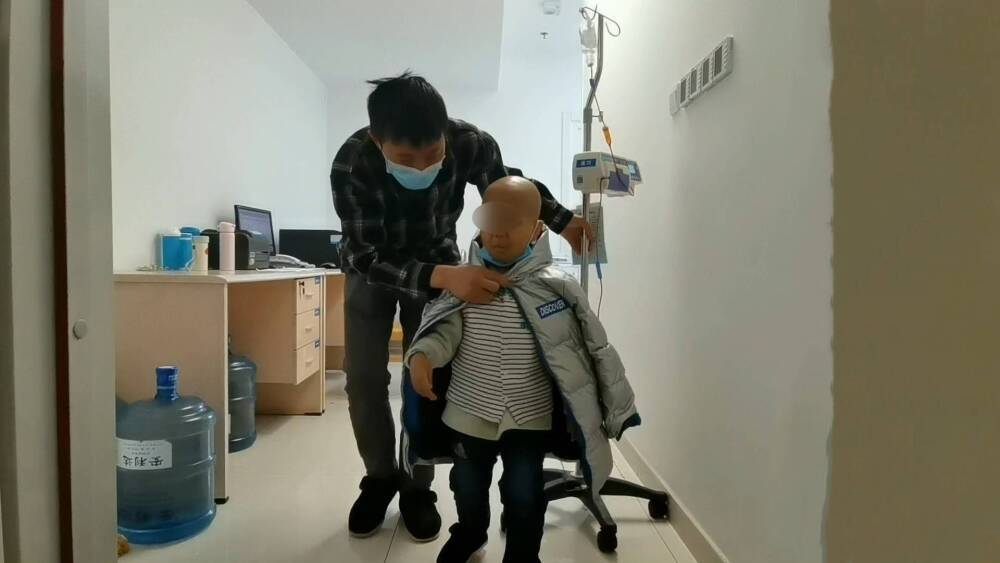 5岁患癌男孩状态稳定“挂床”返回出租屋 动身北京前仍需筹措巨额手术费