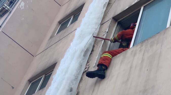 32秒丨日照一居民楼热水器冻裂现20米长冰柱 消防员爬上窗台撬棍除冰