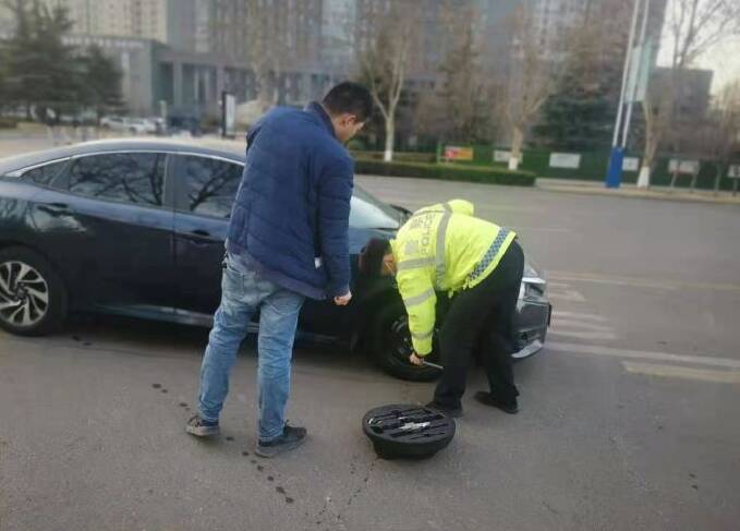 街头上演暖心一幕 邹平交警帮助被困车辆更换轮胎