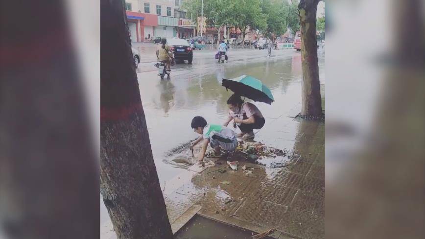 路面积水 滨州邹平一少年与一女子徒手清理下水道堵塞物