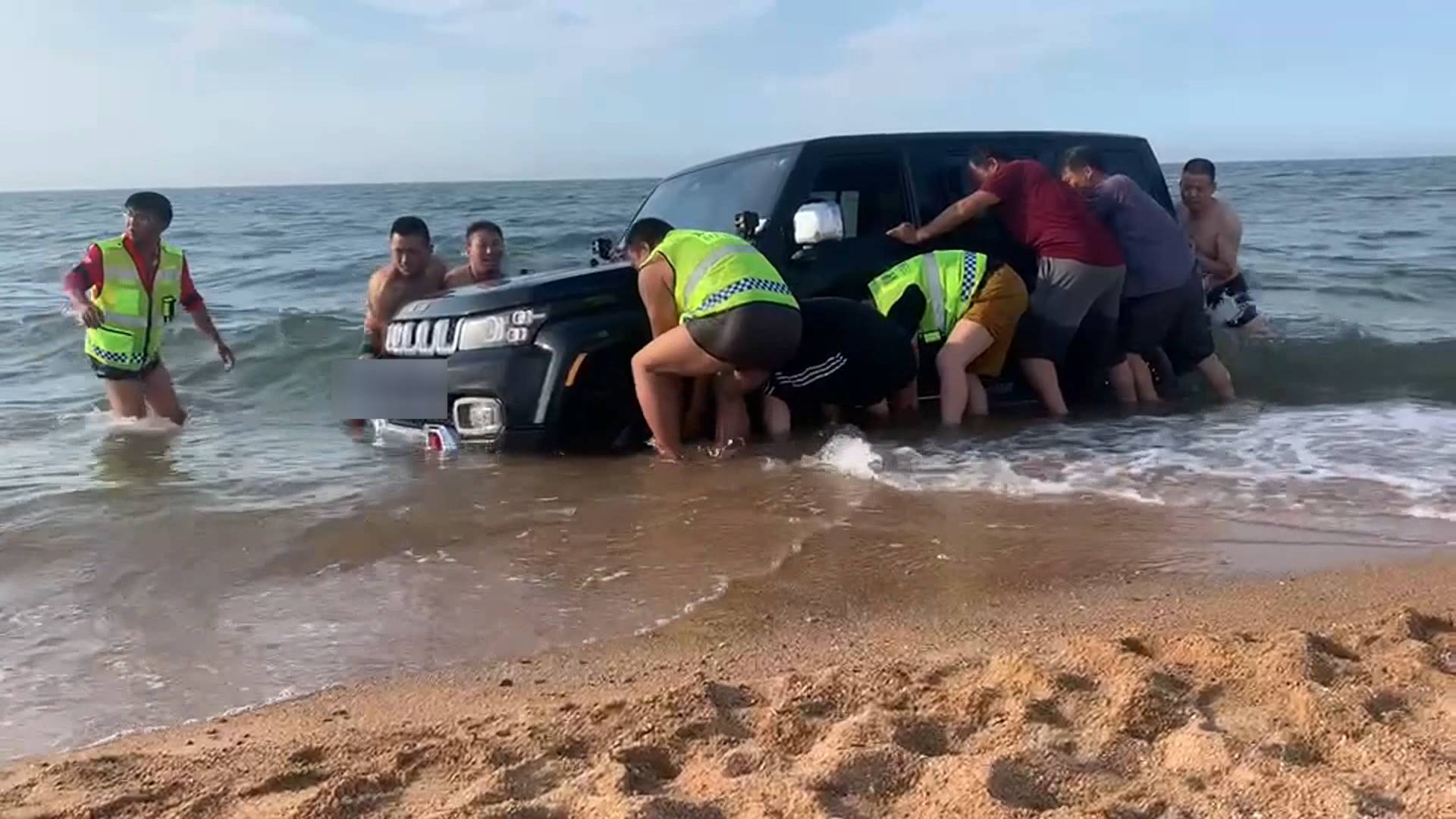 烟台一男子开车海滩上玩耍“深陷”其中 十几个人抬了俩小时救出