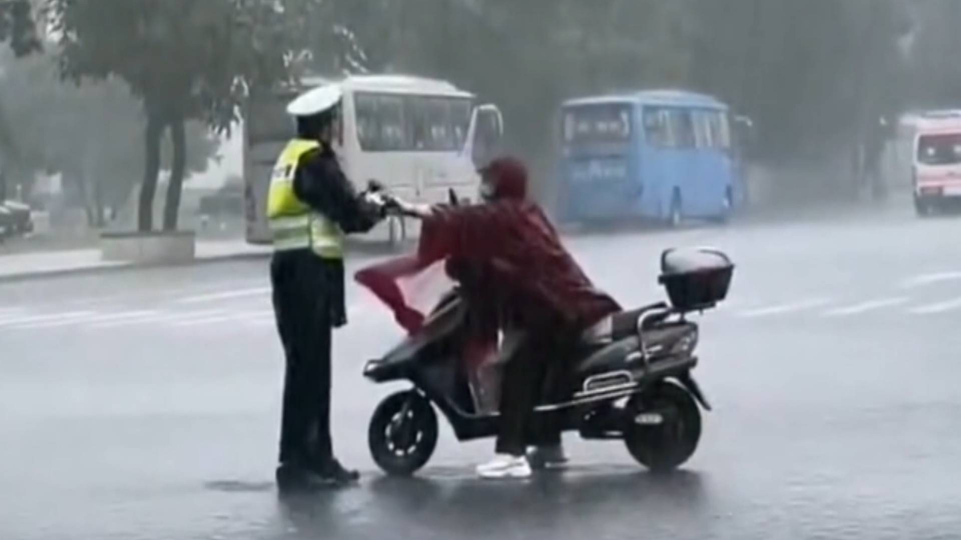 暖心！鄭州一交警雨中指揮交通渾身濕透 市民冒雨送傘