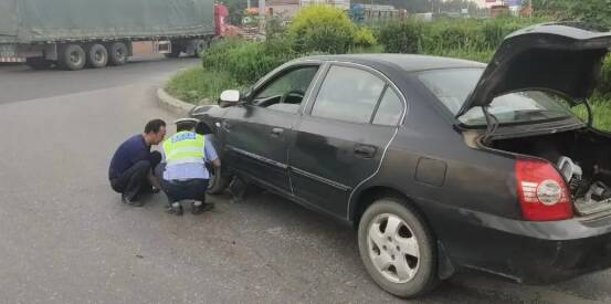 一辆黑色小型轿车因爆胎无法挪动 滨州交警帮忙更换轮胎