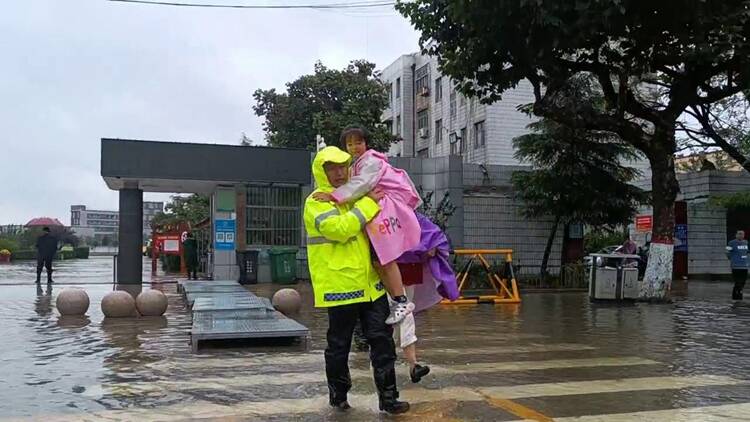 雨中暖心一幕！聊城东阿一学校门口因降雨积水 交警蹚水抱学生过马路
