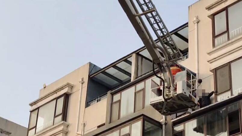 日照一工人封完阳台顶自己却被困住 登高平台消防车将其安全护送至地面