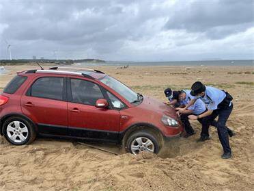 外地游客车子深陷沙滩 威海民警冒雨救援