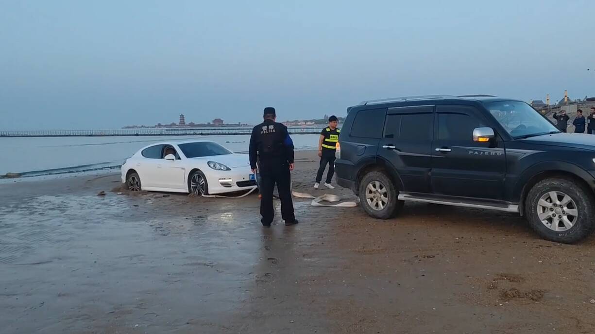 轿车陷进正在涨潮的沙滩 烟台志愿者紧急调来铲车进行施救