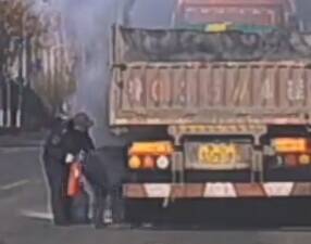 大货车行驶中轮胎起火 淄博两名公交车长接力救援