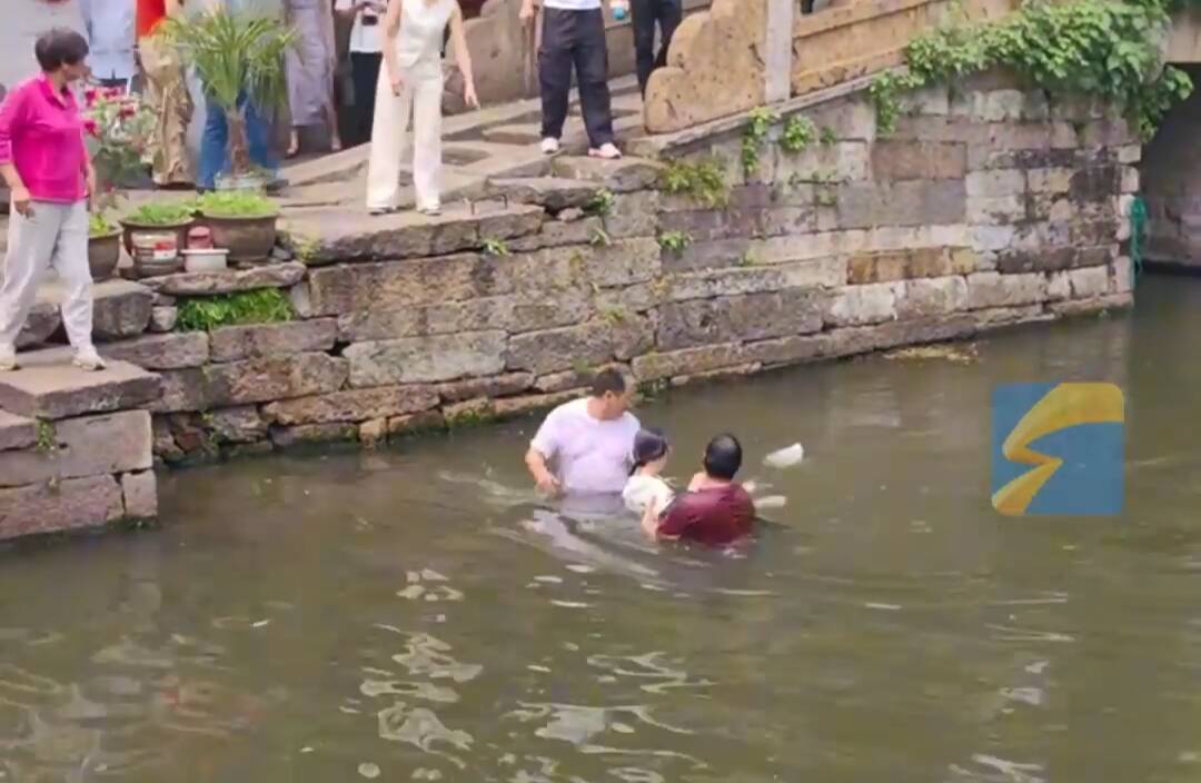 游客拍照落水 两男子合力托举救人