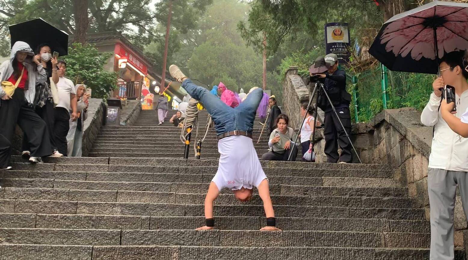 山东勇士冒雨倒立登泰山 已倒立登上全国50座名山