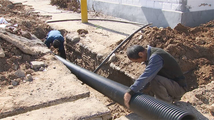 在邹平市九户镇铁匠村,农村生活污水治理工程切割地面,铺设污水管道等