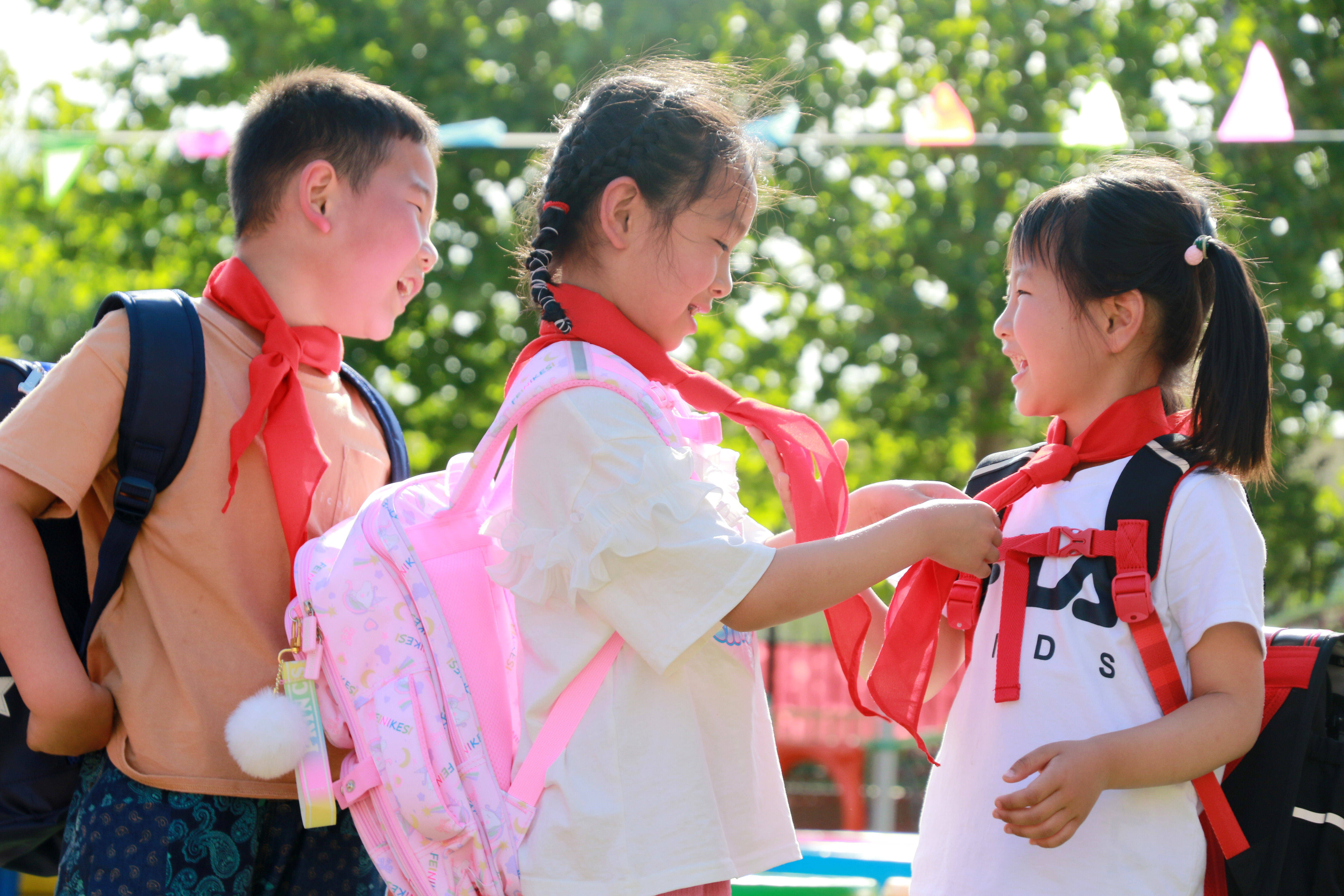 山东省高密市朝阳街道中心幼儿园的孩子们在体验背书包,戴红领巾